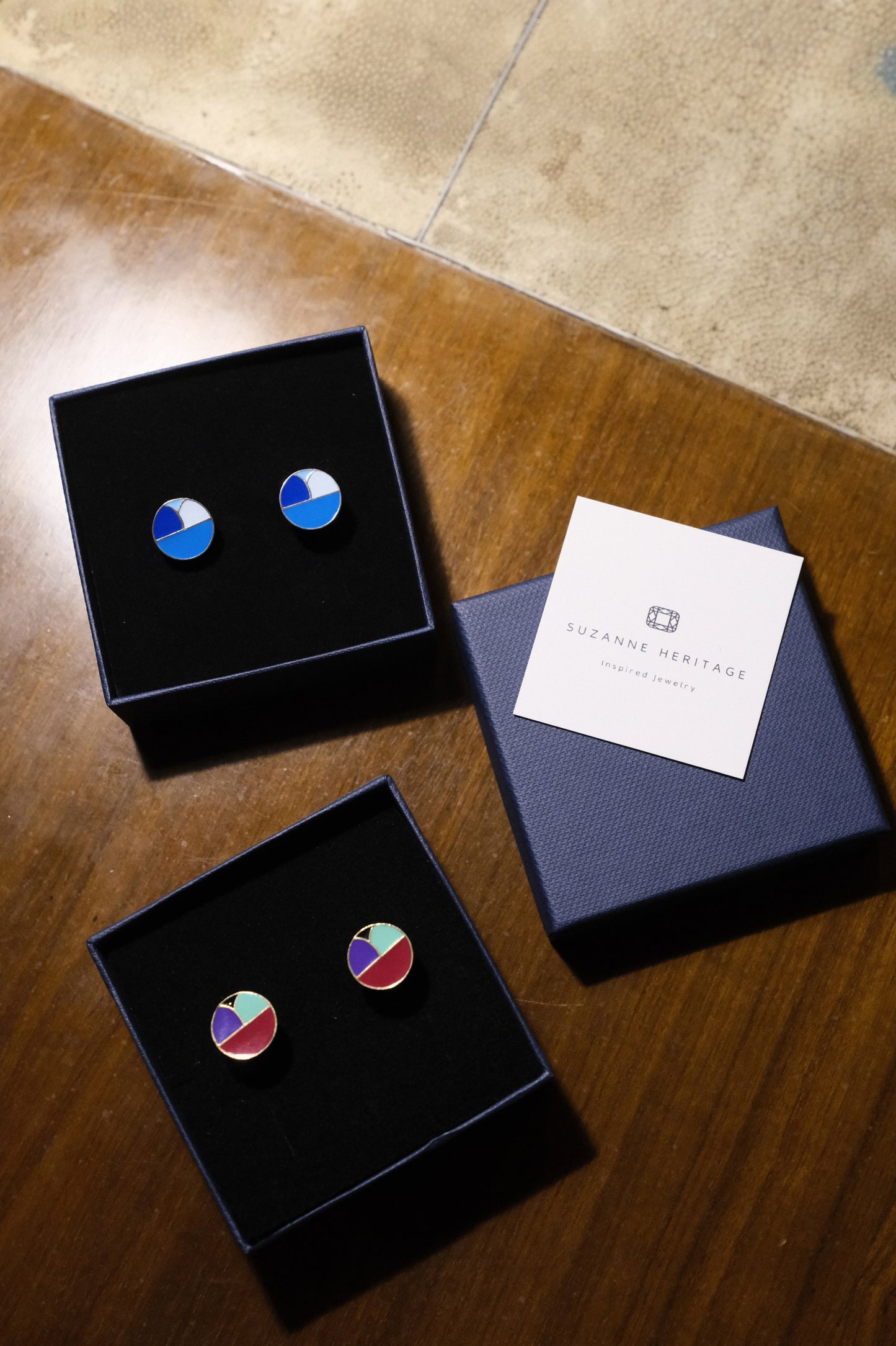 Cosy Corner Cufflinks Blue in stylish gift boxes with geometric patterns on a wooden table.